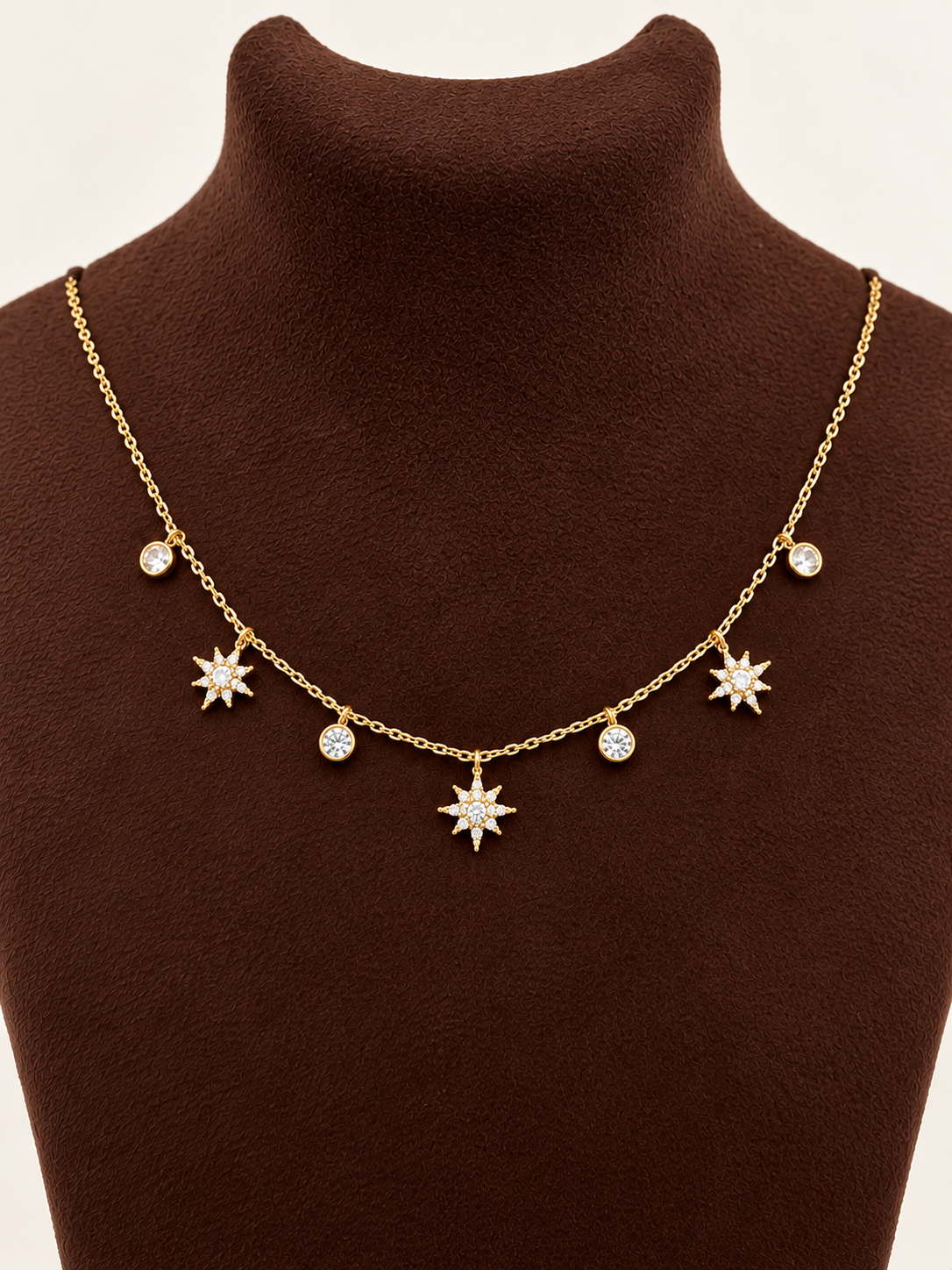 Celestial Starburst Charm Necklace on smooth brown velvet bust, portrait product photo
